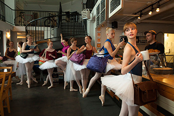 Humorous photo of a group of dancers in tutus. They are standing in line at local Dartmouth coffee shop "Two If By Sea". The are in nonchalant poses waiting to place their order at the counter.
