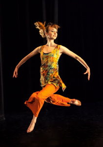 Emma van Zeumeren at Leica Hardy School of Dance performing 'Concordia' in a split leap with bent knees, arms extended in downward curve.