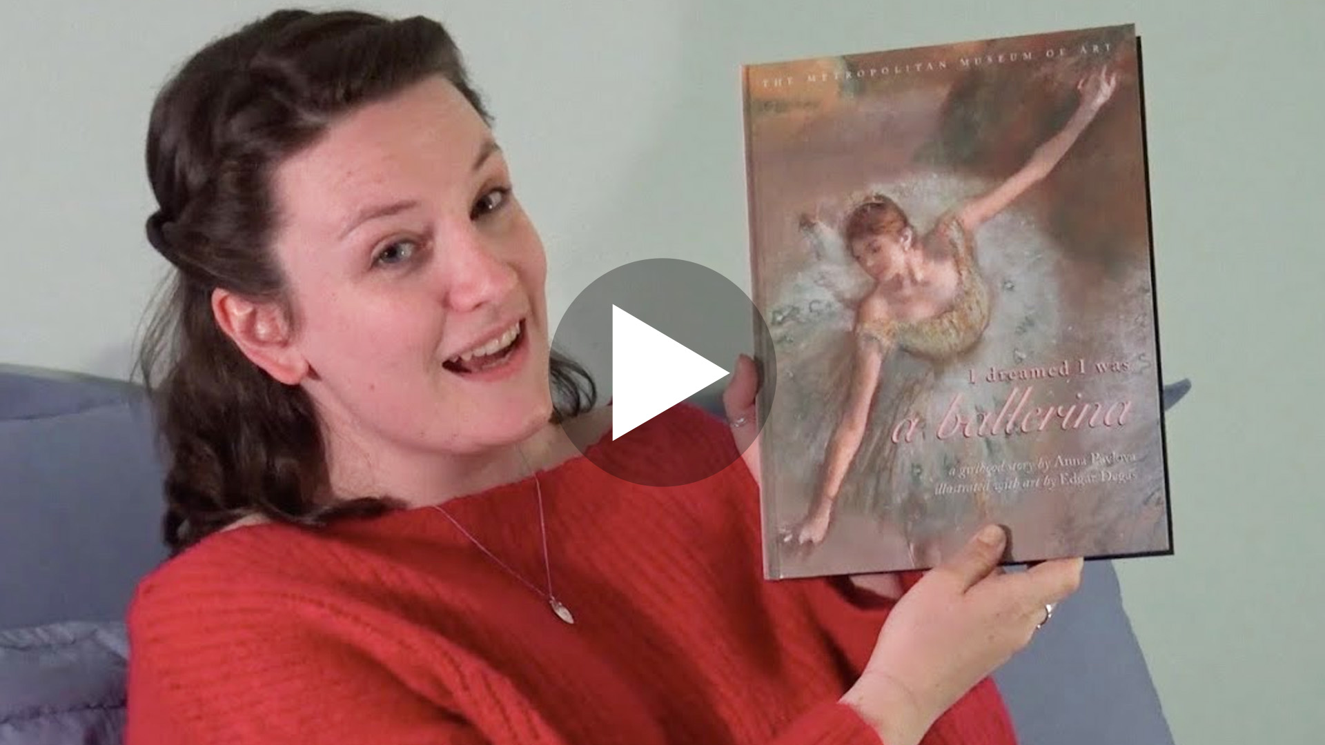 Photo of actor Rebecca Wolfe holding up book titled "I dreamed I was a ballerina". The image is a link to the video of her reading to children.