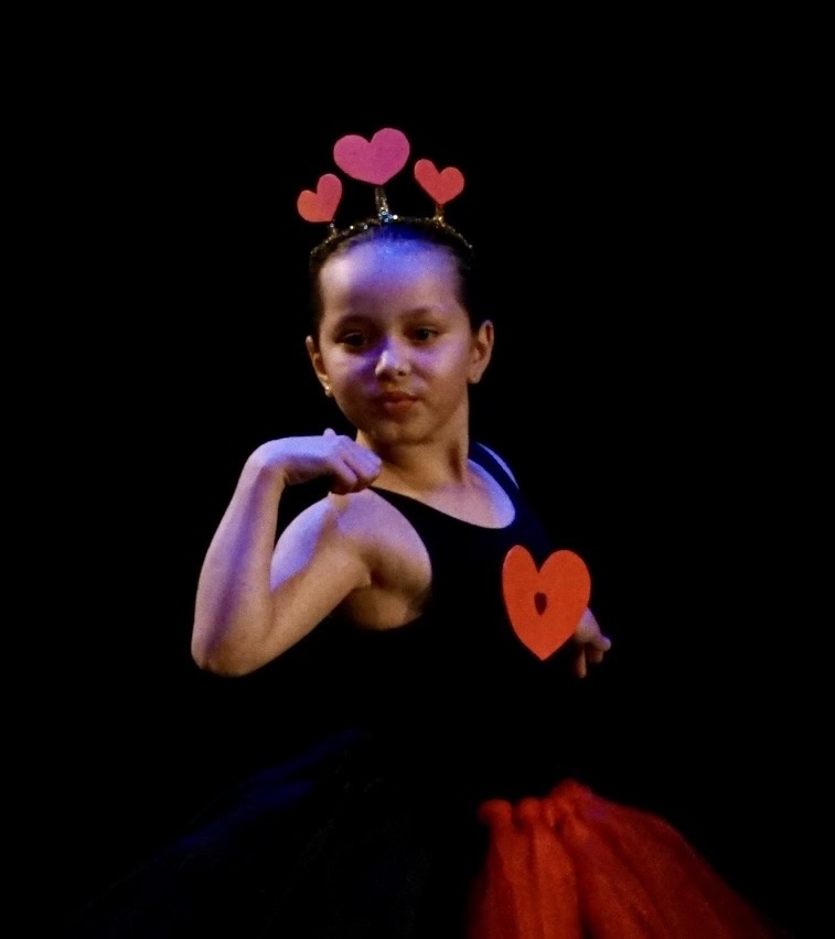 Photo of a young dancer from the Leica Hardy School of Dance with a Valentine's heart headpiece and heart decoration on her torso.